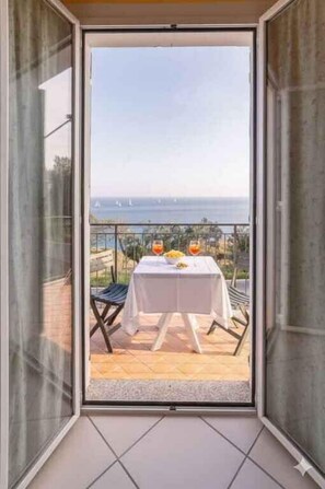 Varanda com mesa posta para dois, com vista panorâmica.