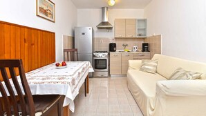 Cozinha compacta com mesa de jantar, sofá e fogão.
