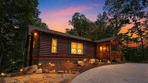 A log cabin with a porch, stone pathway, and a view of the surrounding forest. - Mountain Birdies Log Cabin In Rumbling Bald at Lake Lure! Golf Views! Work Space (Lake Lure)