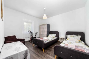 Ein Schlafzimmer mit zwei Betten, einem Tisch, einem Stuhl und einem Fahrrad.