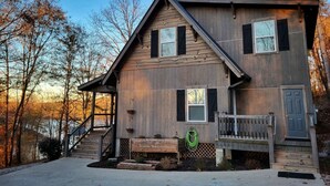 A two-story wooden house with a front porch, a staircase, and a small deck. - Bunk/Game Room, Near Lake, Pet Friendly, Firepit, FUN! (Toccoa)