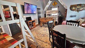 Ein gemütliches Loft-Zimmer mit Fernseher, Holzmöbeln und einer außergewöhnlichen Wanddekoration.