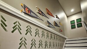 A staircase with a wall featuring state flags and a pattern of arrows. - Bunk/Game Room, Near Lake, Pet Friendly, Firepit, FUN! (Toccoa)