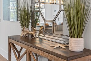 A wooden table with decorative items including a crab, starfish, and tall green plants in white pots. - .5 miles to beach~Private Pool~Dogs OK~EV Charger (Santa Rosa Beach)