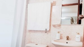 Un baño con inodoro, lavabo y espejo.