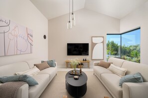 A modern living room with two sofas, a coffee table, a flat-screen TV, and a large window with a view. - Villa Modrić (Istria - Pazin) (Pazin)