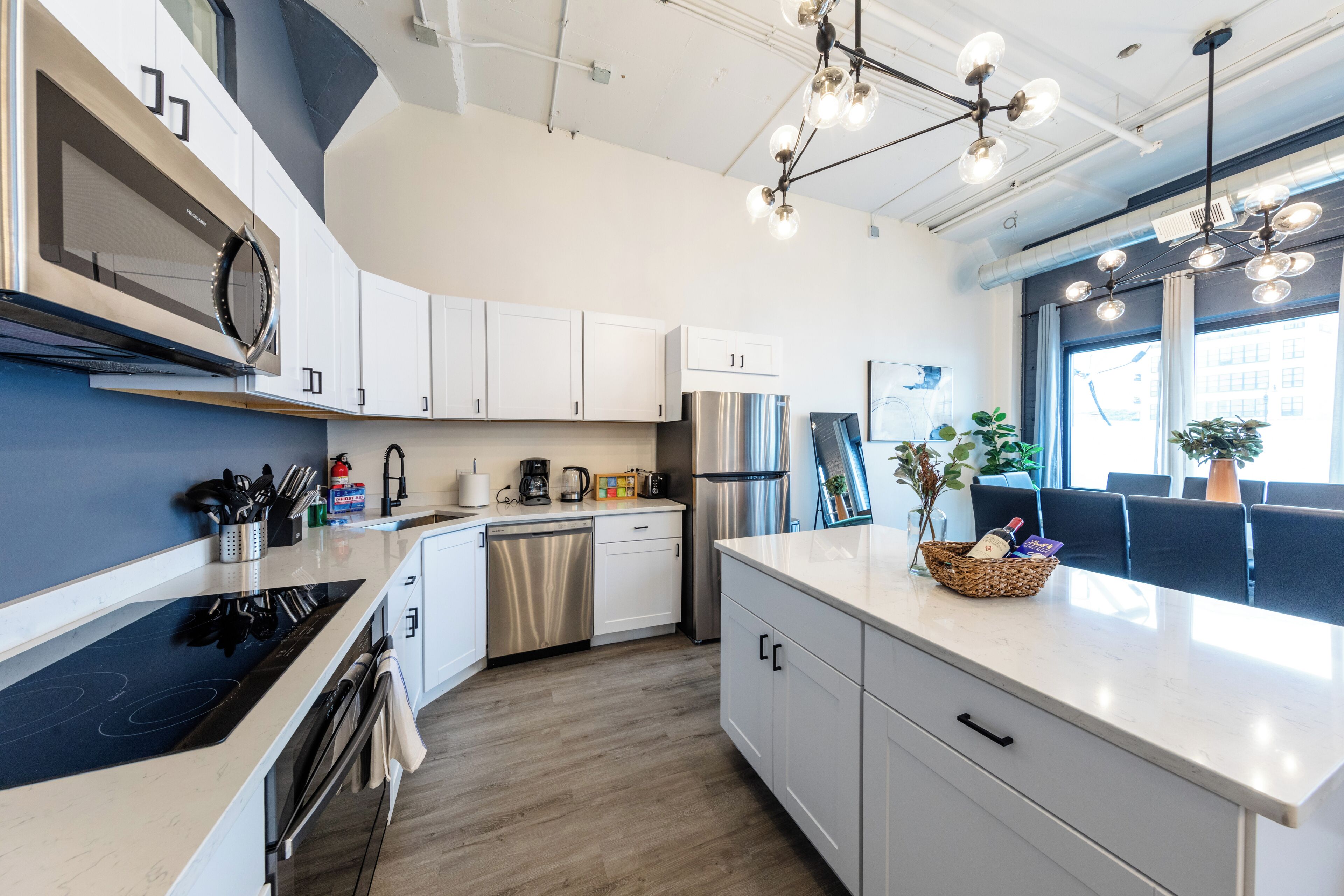 A modern kitchen with stainless steel appliances, white cabinetry, and a central island.