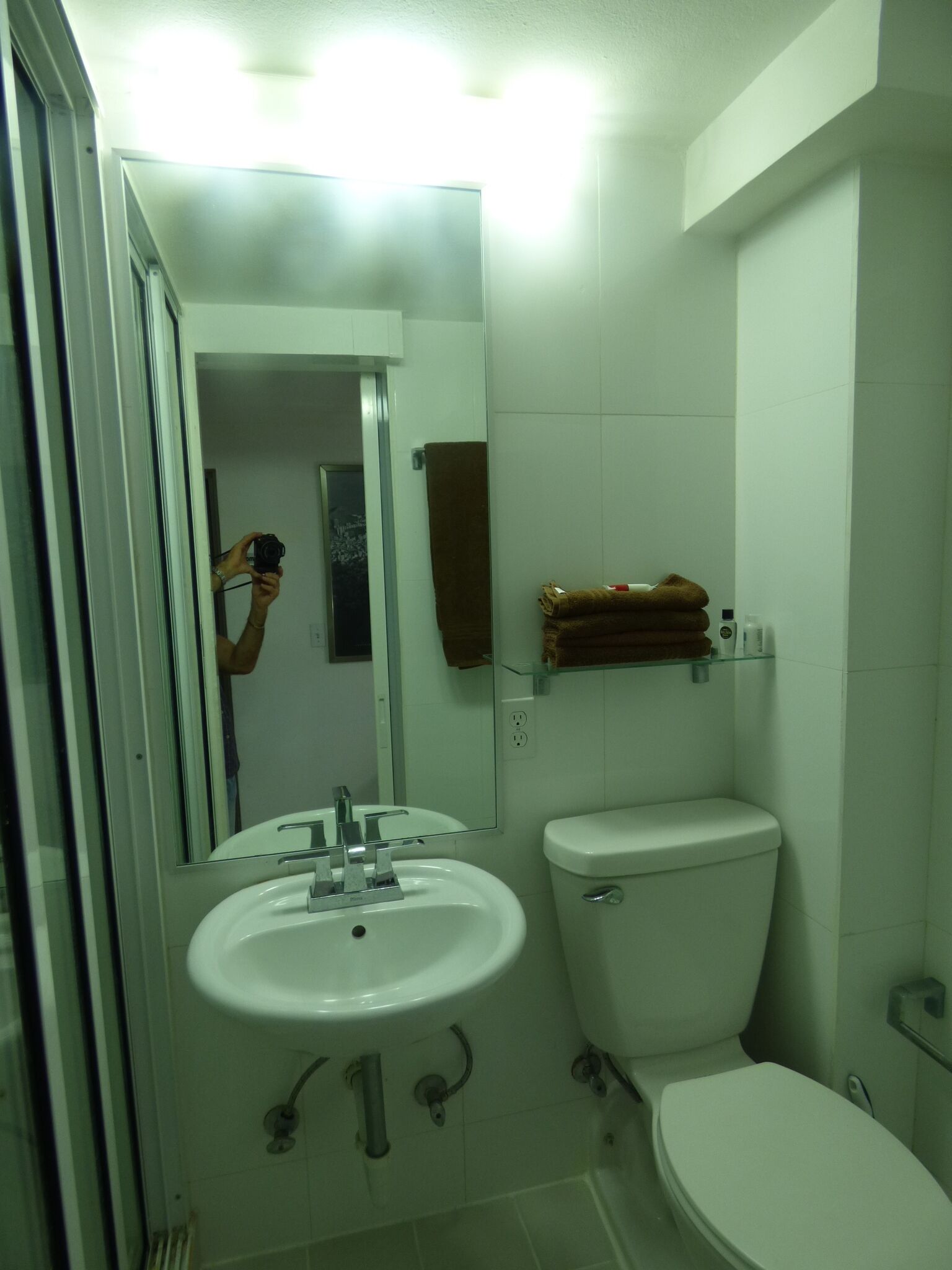 Ein Badezimmer mit Waschbecken, Toilette und einer Duschkabine aus Glas.