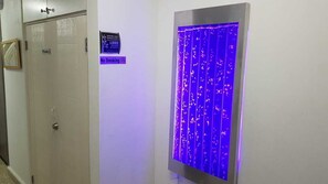 Eine private Tür mit einem Schild, das Rauchen verbietet, und einem blau beleuchteten Panel.