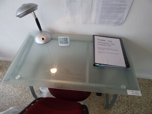 Ein Tisch mit Glasplatte, eine Schreibtischlampe und ein Schild mit der Aufschrift 'Insider List'.