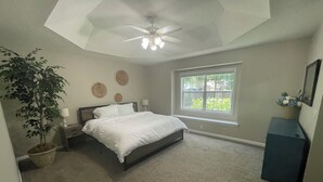 A bedroom with a bed, a ceiling fan, a window, a plant, and a dresser. - Beautiful 3-bedroom home near Southeast hospital and downtown Dothan (Dothan)