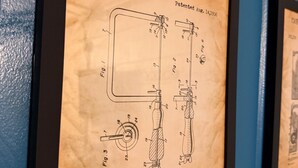 Un dessin de brevet encadré représentant une scie à chantourner, comprenant des schémas et des mesures détaillés.