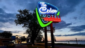 A neon sign for 'The Cedars Motel' with a 'No Vacancy' sign below it. - The Naturalist`s Cabin at The Cedar (Sandusky)