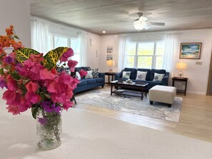 Ein Wohnzimmer mit einer Couch, einem Couchtisch und einer dekorativen Vase mit Blumen.