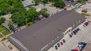 An aerial view of a large building with a flat roof, labeled 'LAWSON DISTRICT,' surrounded by a parking lot with various cars.