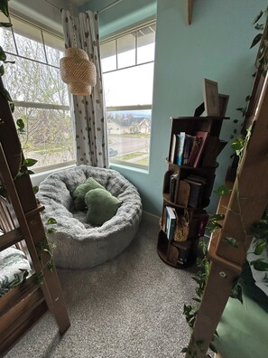 A cozy room with a pet bed, a bookshelf, and a window with a view of houses. - Private Pickleball, Basketball, Gaming Room! (Eagle)