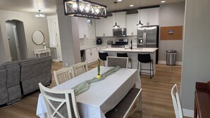 Una cucina moderna con mobili bianchi, elettrodomestici in acciaio inossidabile e un'isola centrale.