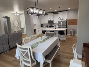 A modern kitchen with white cabinets, stainless steel appliances, and a central island. - Private Pickleball, Basketball, Gaming Room! (Eagle)