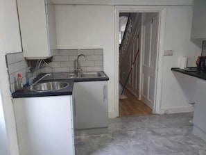 A kitchen with two sinks, a microwave, and a refrigerator.