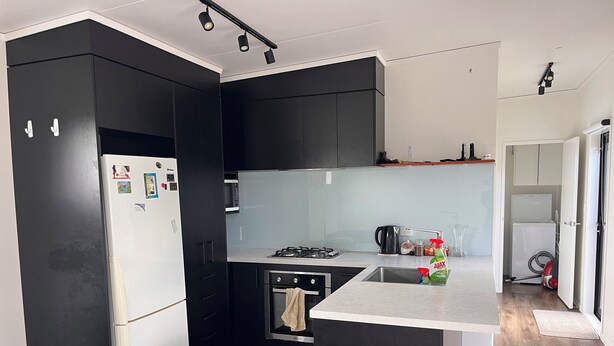 Eine moderne Küche mit Kühlschrank, Mikrowelle, Herd, Spüle und Schränken.