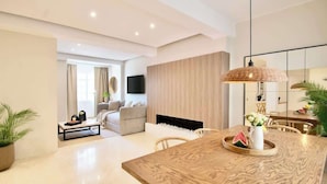 A modern living room with a wooden dining table, a sofa, and a fireplace. - Nala - Increíble 3BR en CDMX, Col. Cuauhtémoc (Mexico City)