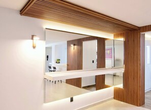 Ein modernes Interieur mit einem großen Spiegel, Holzvertäfelung und einem weißen Empfangsschalter.