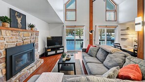 A living room with a fireplace, a television, a sofa, and a dining area with a table and chairs.