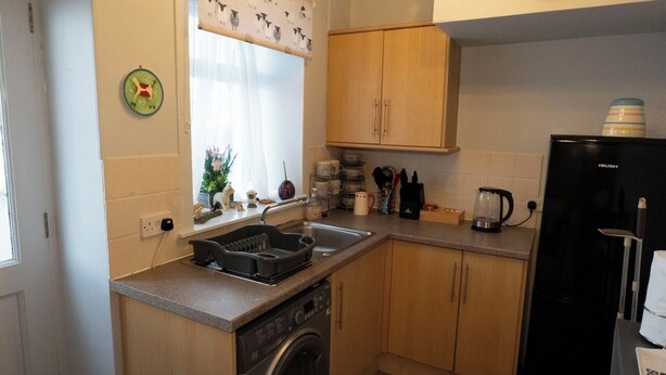 A compact kitchen with a washing machine, a sink, and a refrigerator. - 1BR Charming Cottage in Central Moffat (Moffatt)