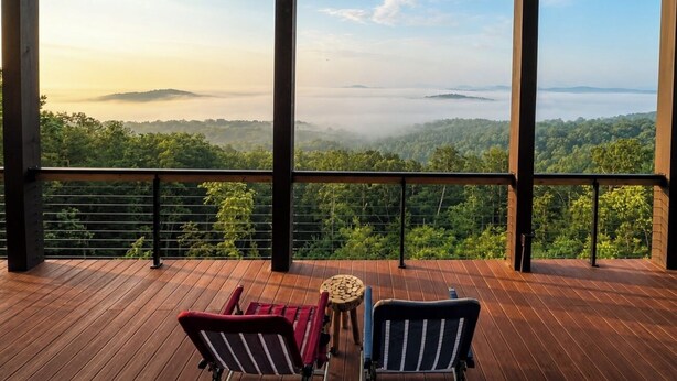 A wooden deck with two chairs and a small table, overlooking a forested landscape with distant mountains. - Above the Clouds Luxury Retreat with Hot Tub and Epic Views (Morganton)