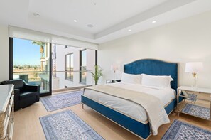 A modern hotel room with a large bed, a balcony with a view, and a desk with a chair. - Luxury Brand-New Apartment with Pool-Ritz Resort (Paradise Valley)