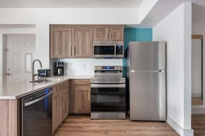 Une cuisine moderne avec des meubles en bois, des appareils en acier inoxydable et un lave-vaisselle.