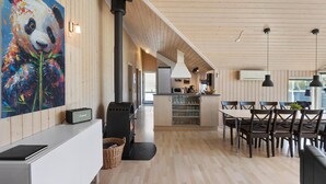 Een modern interieur met een keuken, een eethoek en een groot schilderij van een panda.