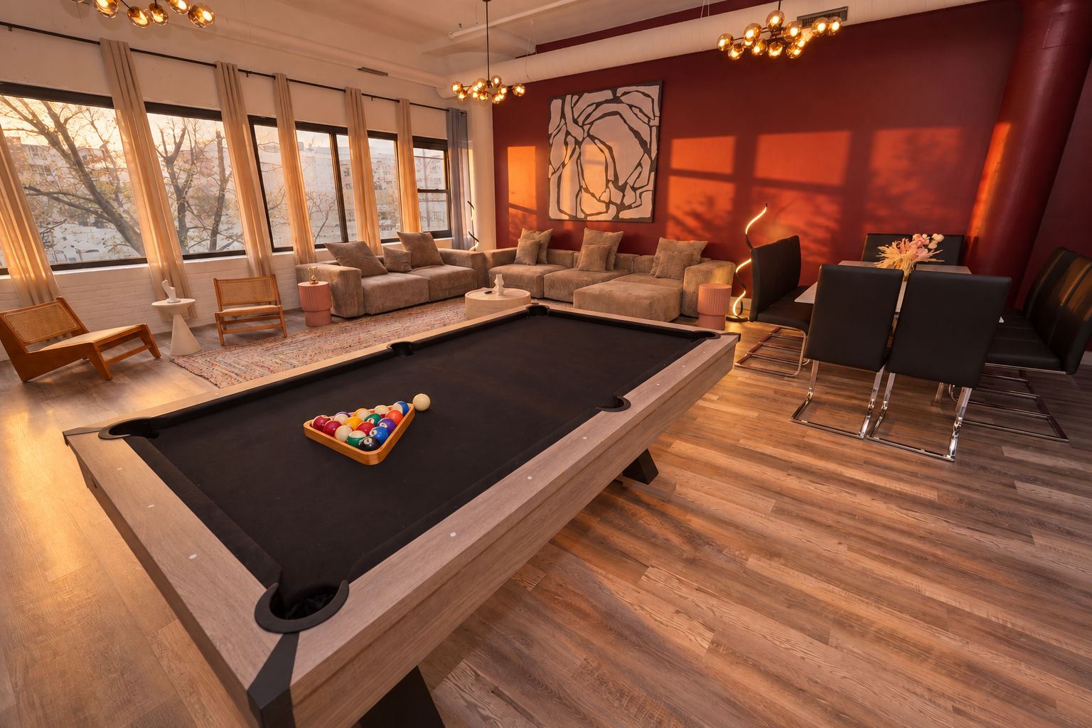 A pool table with balls, a sofa set, and a dining area with chairs.