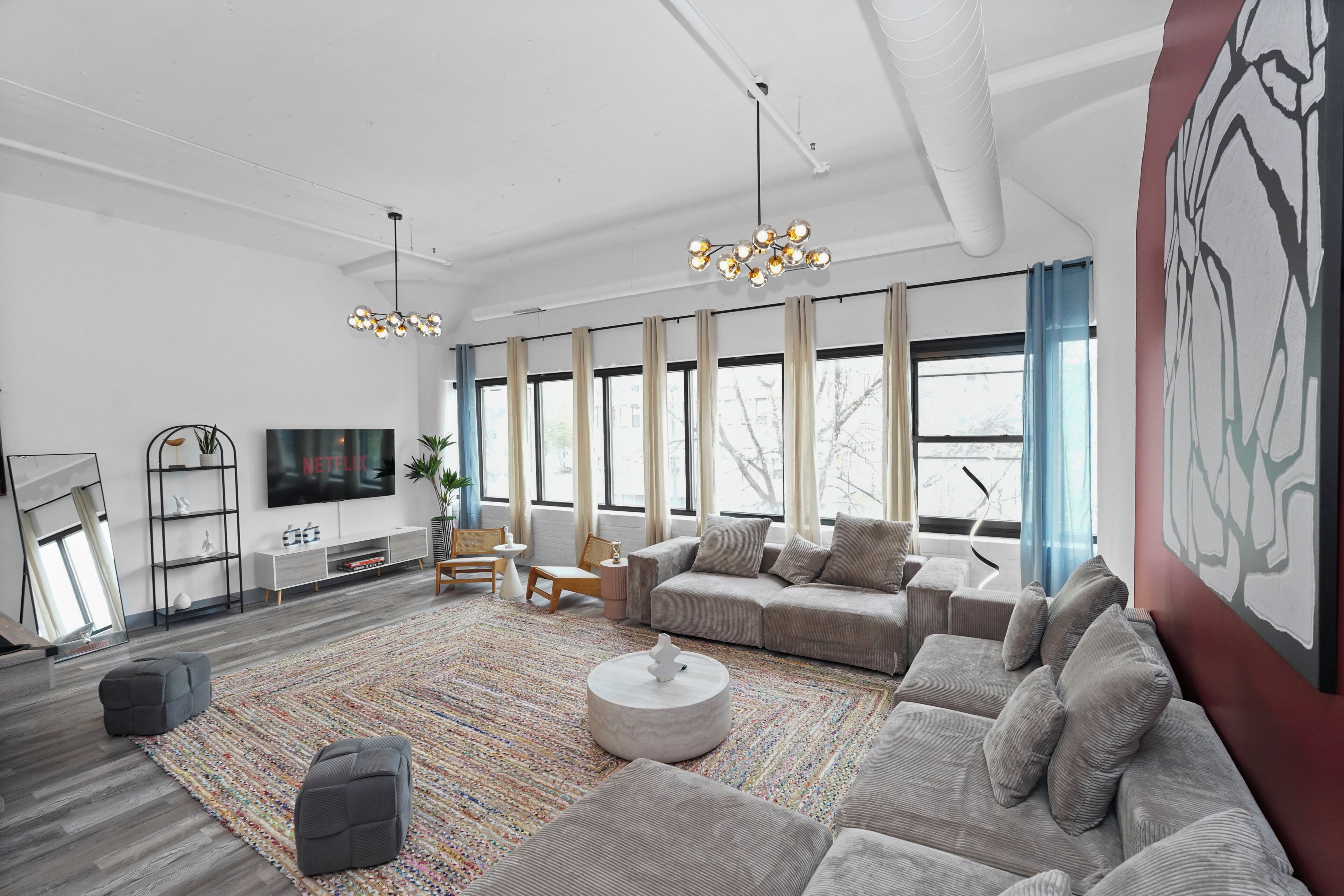 A modern living room with a large sofa, a coffee table, and a TV.