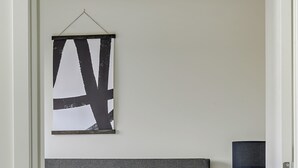 Una cama bien hecha con cabecera gris, una almohada marrón y una manta decorativa.