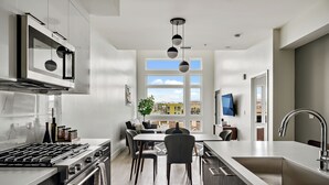 Una cocina moderna con estufa a gas, horno y un amplio ventanal con vista a la ciudad.