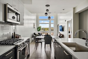 Una cocina moderna con estufa a gas, horno y un amplio ventanal con vista a la ciudad.