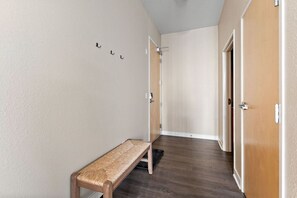A hallway with a bench, a coat rack, and two doors. - MSP Voyager | By Childrens Hospital | Free Parking (Minneapolis)