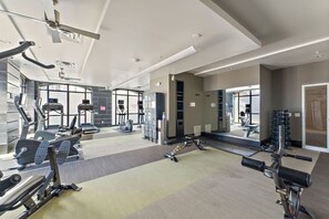 A modern gym with cardio machines, free weights, and a mirrored wall. - MSP Voyager | By Childrens Hospital | Free Parking (Minneapolis)