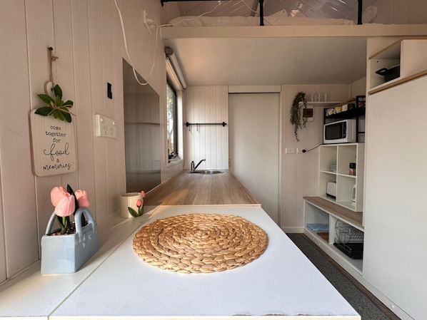 Une cuisine moderne dotée d’un îlot central, d’un four à micro-ondes et d’un évier.