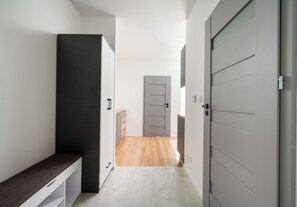 Ein Flur mit einer Bank, einem Schrank und einer Tür zu einem weiteren Zimmer.