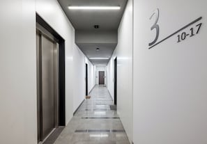 Ein langer, schmaler Flur mit der Beschriftung '3' und '10-17' an der Wand, welche Zimmernummern kennzeichnet.