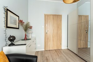 Ein modernes Zimmer mit Holztür, Spiegel, Globus und Schreibtisch mit Lampe.