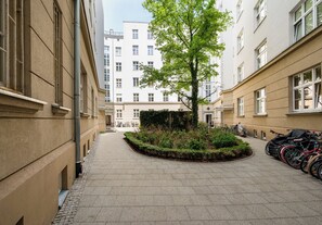 Ein Innenhof mit Baum, Fahrrädern und Gebäuden.