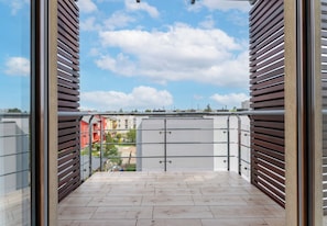 Un balcon avec vue sur les bâtiments et un ciel dégagé.