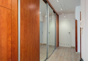 Un couloir avec des lambris en bois, une porte-fenêtre coulissante et une porte blanche.