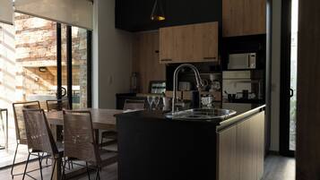 Coffee/tea maker, oven, cookware/dishes/utensils, dining tables