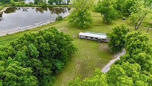 Ein eingeschossiges Gebäude mit Gründach, umgeben von üppiger Bepflanzung und einem Teich.