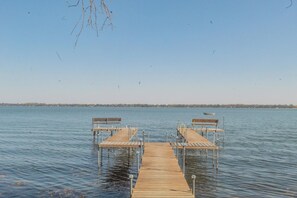 A wooden pier extending into calm water with benches at the ends. - Cozy Waterfront Cabin on Big Spirit Lake (Orleans)