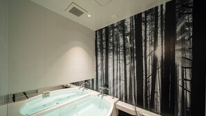A bathroom with a large bathtub, a mirror, and a forest-themed wall mural. - HOTEL KEI - Adults Only  (Himeji)
